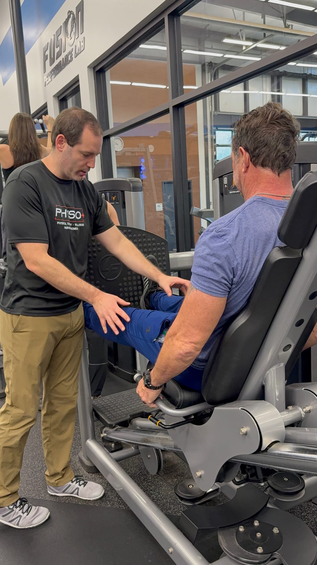 Physio+ DPT assessing a patient on the leg press at Fusion Performance Lab